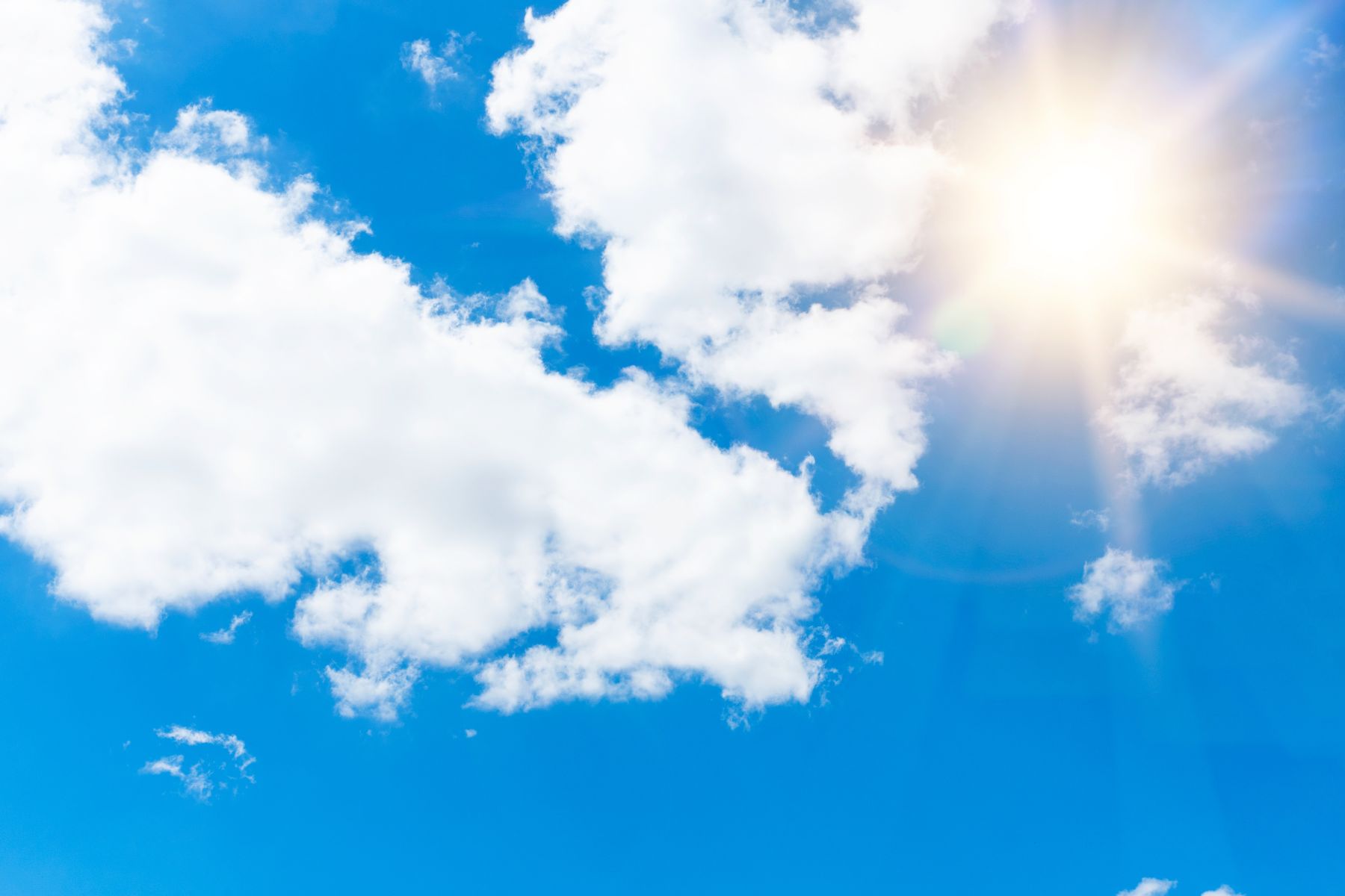 photo of the hot sun and some clouds in the sky-canva image